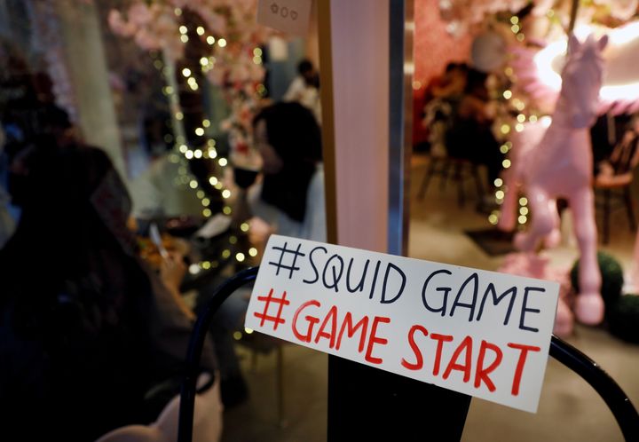 Μια πινακίδα που αναφέρεται σε ένα παιχνίδι πρόκληση που εμφανίζεται στη νέα επιτυχία του Netflix "Squid Game" στο Brown Butter Cafe στη Σιγκαπούρη.