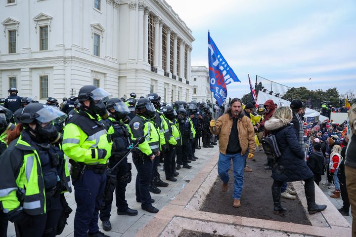 Wren, holding a Trump flag, passes a line of police officers at the Capitol on Jan. 6.