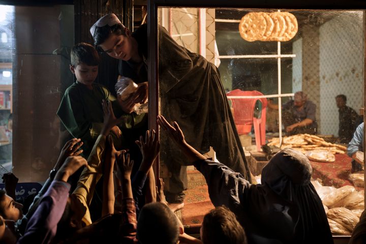 Σεπτέμβριος 2021 Καμπούλ. Γυναίκες και παιδιά περιμένουν έξω από ένα φούρνο για να πάρουν δωρεάν ψωμί.