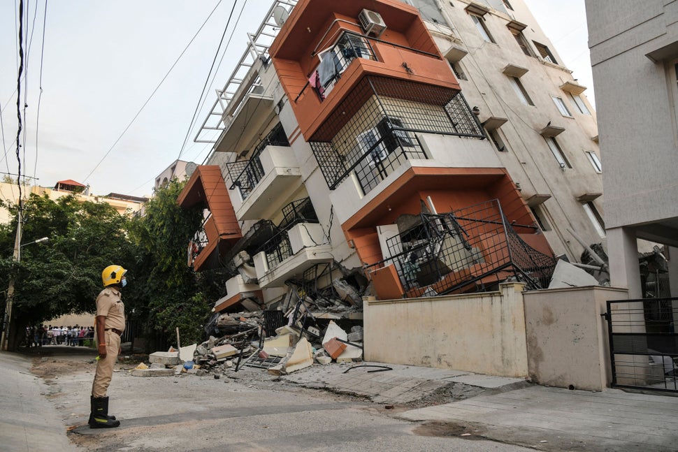 An emergency responder watches a multistory apartment building that collapsed without any reported casualties...