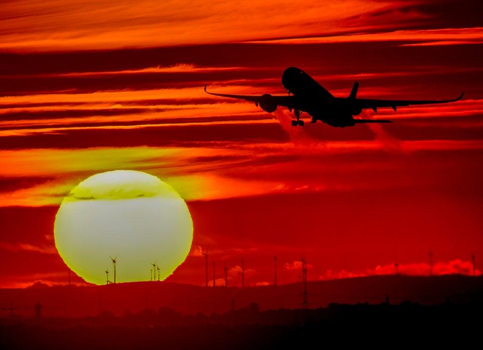 An aircraft takes off at the international airport as the sun sets in Frankfurt, Germany, on Oct.