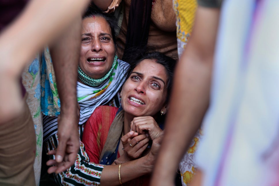 Aradhana, center, wife of Deepak Chand, a schoolteacher who was killed in Kashmir, mourns before the...