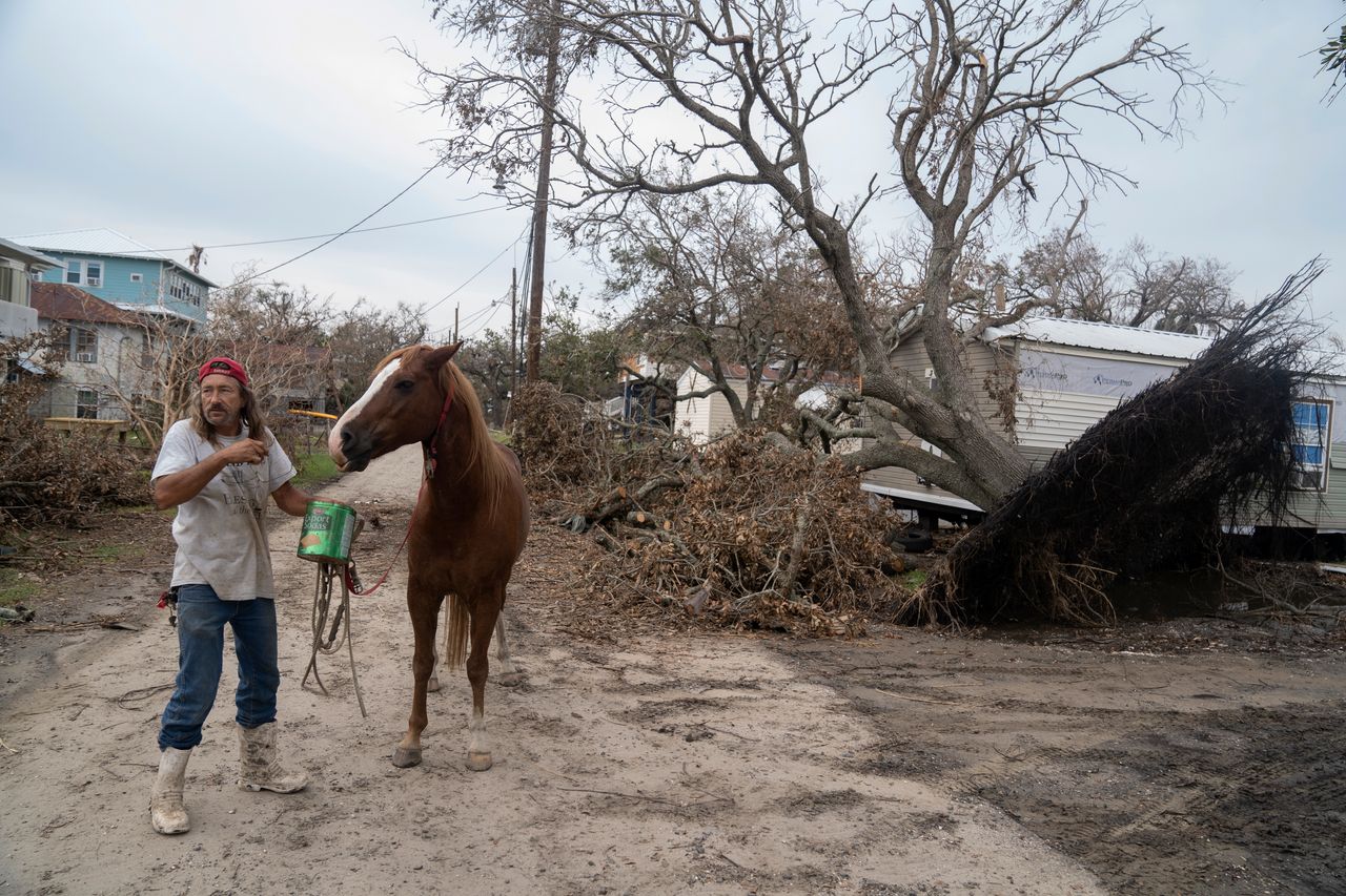 Grand Isle, Louisiana, resident Charlie Walker takes his landlord's horse, Whip, on a walk near his mobile home on Sept. 8.