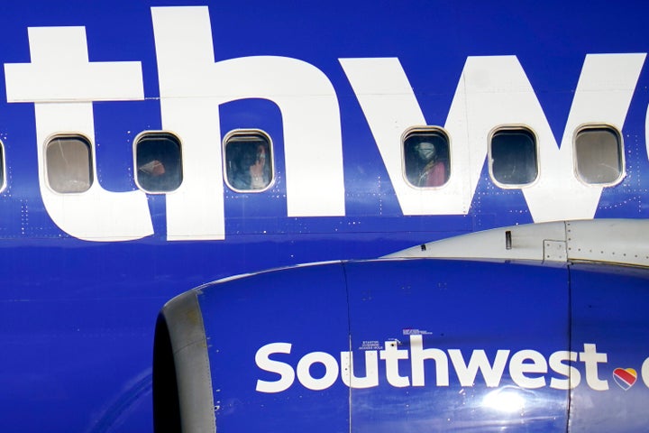 People are seen wearing face masks to protect against COVID-19 while riding on a Southwest Airlines flight from Norfolk, Va., making its landing approach into Baltimore-Washington International Thurgood Marshall Airport.