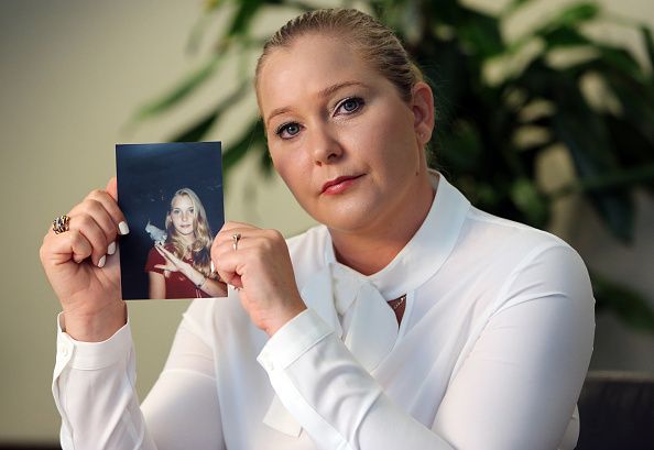 Virginia Roberts holds a photo of herself at age 16