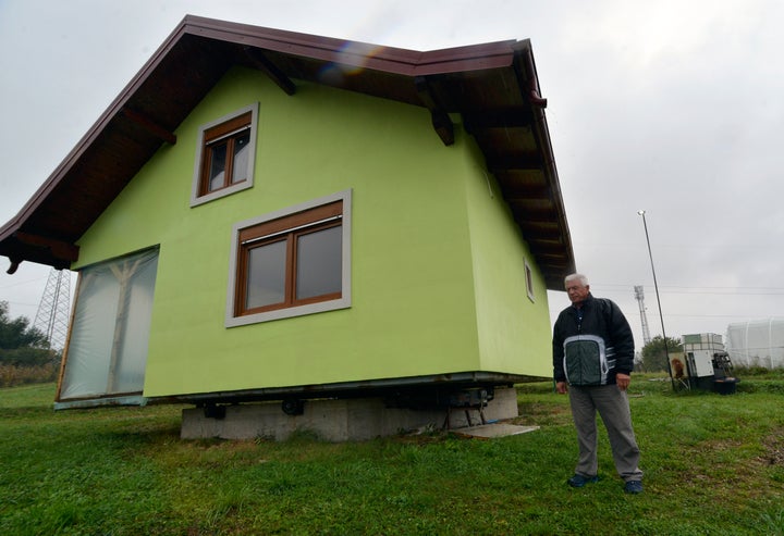 Vojin Kusic's stands in front of his rotating house in a town of Srbac, northern Bosnia, Sunday, Oct. 10, 2021. The house can rotate a full circle to satisfy his wife's shifting desires as to what she should see when she looks out of the windows of her home. (AP Photo/Radivoje Pavicic)