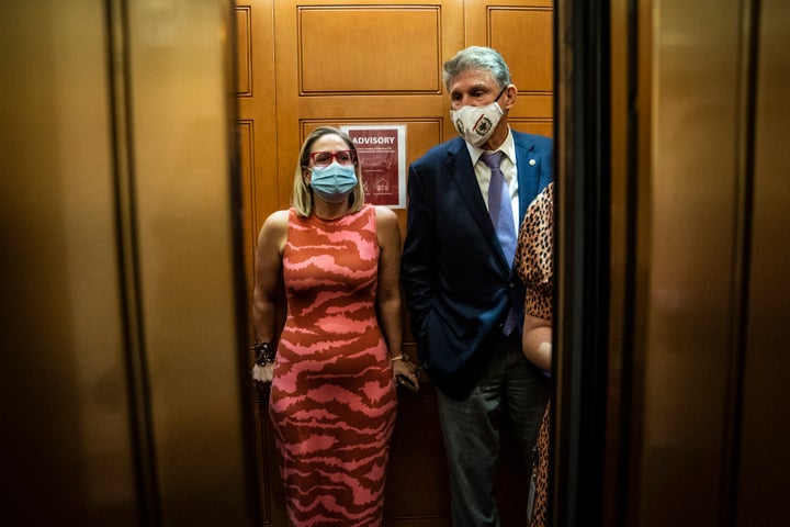 Sen. Kyrsten Sinema (D-Ariz.) and Sen. Joe Manchin (D-W.Va.) board an elevator on Capitol Hill, Sept. 30, 2021.