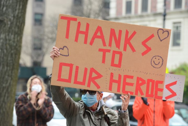 ニューヨーク市中の病院の入り口で、看護師や医師に感謝のサインを掲げる男性（2020年4月23日撮影）
