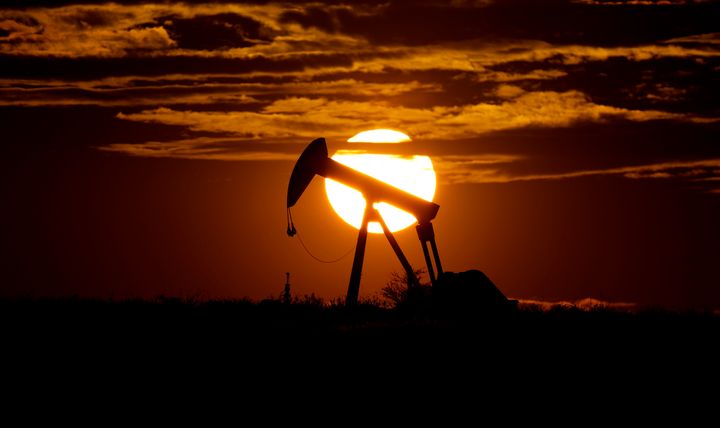 8 Aπριλίου 2020. Ο ήλιος δύει πίσω από μία εγκατάσταση άντλησης πετρελαίου στο Καρνς Σίτι των ΗΠΑ. Η ανθρωπότητα αγωνίζεται να σηκώσει κεφάλι από την πανδημία, ωστόσο η ζήτηση για ενέργεια εξελίσσεται σε σταυρόλεξο για πολύ δυνατούς λύτες. (AP Photo/Eric Gay, File)