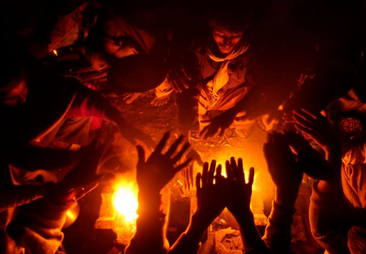 Φωτογραφία αρχείου, 2 Ιανουαρίου 2008. Μία ομάδα φτωχών Ινδών, καθώς απλώνουν τα χέρια τους πάνω από τη φωτιά, μία κρύα νύχτα στα βόρεια της χώρας, στην πόλη Λούκνο. Το ψύχος θερίζει άστεγους και φτωχούς στην Ινδία. REUTERS/Pawan Kumar (INDIA)
