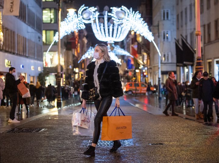Shoppers pass Christmas light displays on New Bond Street in central London. (Photo by Dominic Lipinski/PA Images via Getty Images)