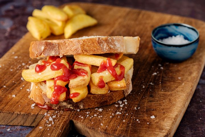 A staple of the english diet a “Chip Butty”. Potato fries between two slices of buttered white bread, with tomato ketchup! A snack, a meal, a hangover cure, you decide! Delicious. Colour, horizontal with some copy space.