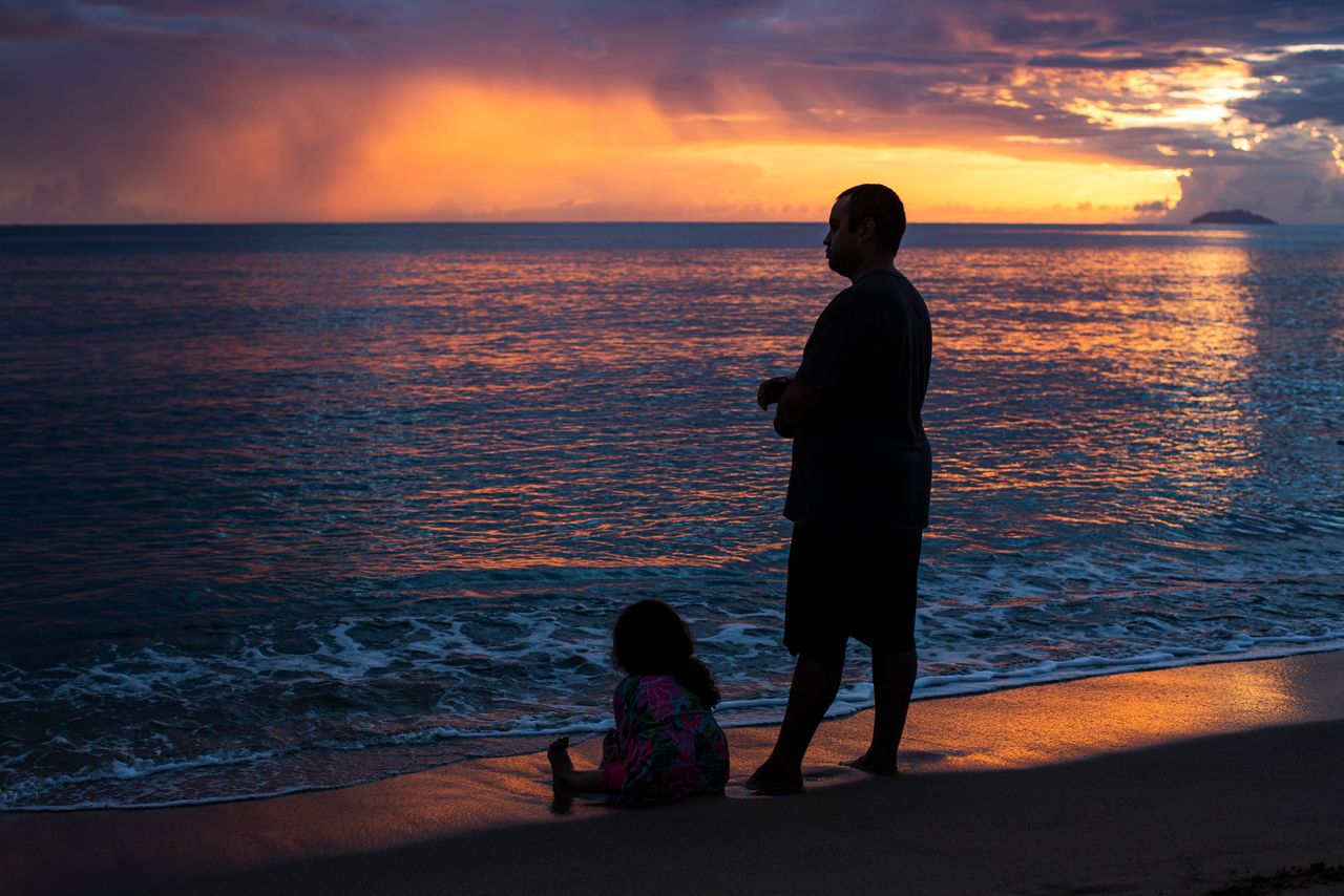 People observe the sunset at Los Almendros beach in Rincón, Puerto Rico, on Aug. 2.
