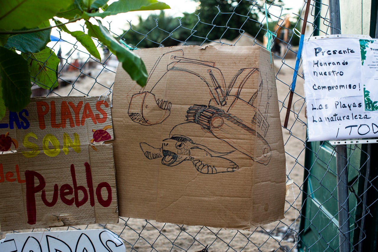 Signs of protest hang on the fence of the residential building.