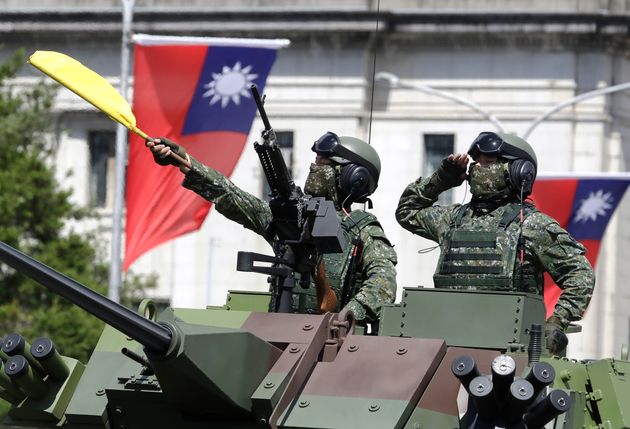 Taiwanese soldiers salute during National Day celebrations in front of the Presidential Building in Taipei,...