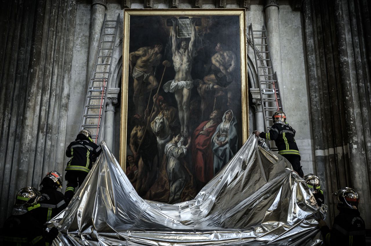 French firefighters protect a painting with a fireproof blanket during a fire drill aimed at preserving artworks displayed in the Saint-Andre cathedral in Bordeaux, southwestern France, on Oct. 12. 