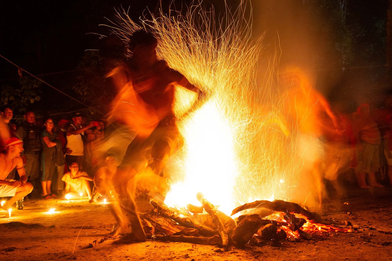 People take part in the Baile de la Candela (fire dance) religious ceremony on the Sorte mountain, in Yaracuy state, Venezuela, on Oct. 12. Thousands of pilgrims gather in the mountains to worship Maria Lionza and other spirits of a new religious movement which is a blend of African, Indigenous and Catholic beliefs. 