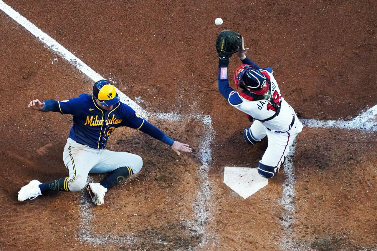 The Milwaukee Brewers' Avisail Garcia slides into home as Atlanta Braves catcher Travis d'Arnaud misses the tag during the fourth inning of Game 4 of the National League Division Series in Atlanta, on Oct. 12.