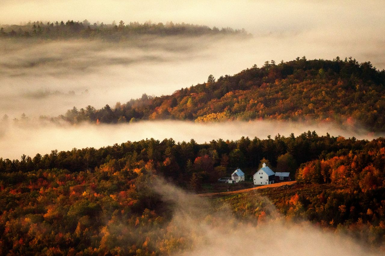 Valley fog wafts through the autumn-colored hills near the Picket Hill Farm in Denmark, Maine, on Oct. 13. 