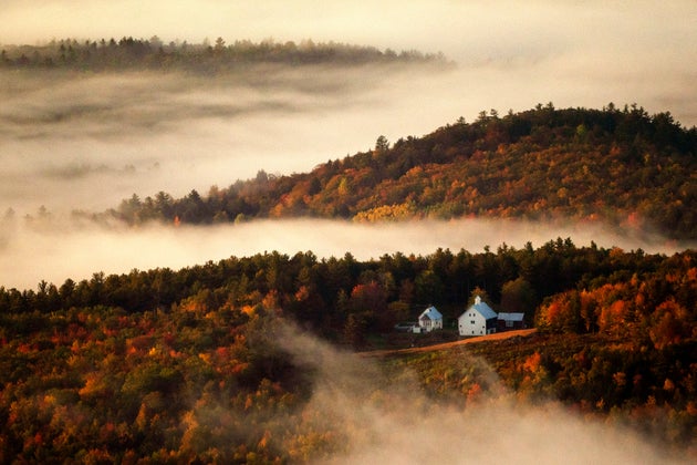 Valley fog wafts through the autumn-colored hills near the Picket Hill Farm in Denmark, Maine, on...