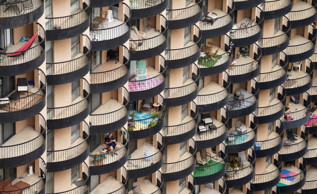A man sits on his balcony at an apartment building in Arlington, Virginia, on Oct.