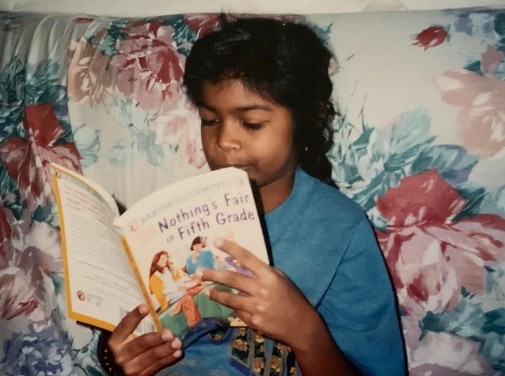 The author, age 8, pretending to read a book.
