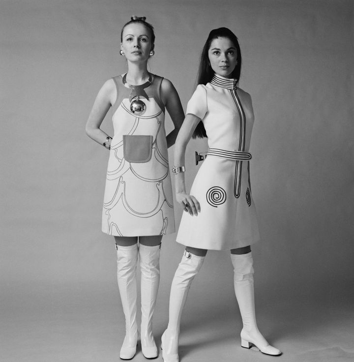 Two U.K. models wear sleeveless short dress with white over the knee go-go boots in January 1970. 