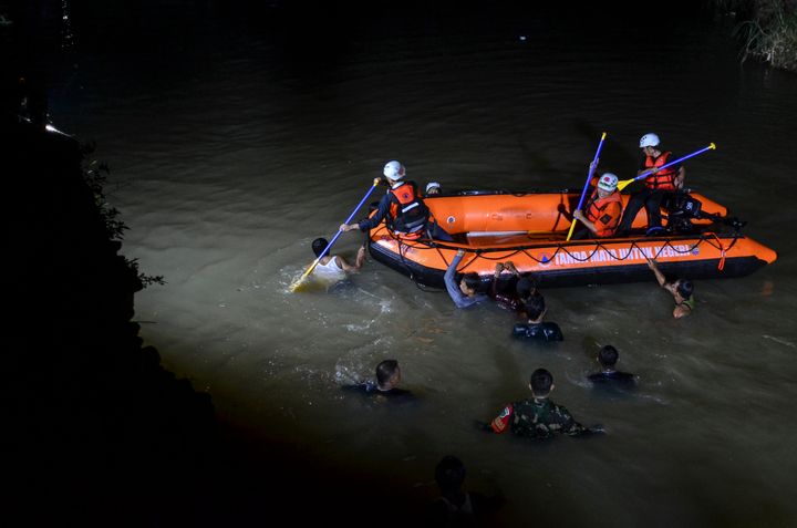 Rescuers search for victims in a river in Ciamis, West Java, Indonesia.