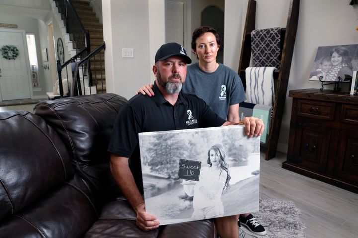 David and Wendy Mills hold a photo of their late daughter at their home in Spring, Texas.