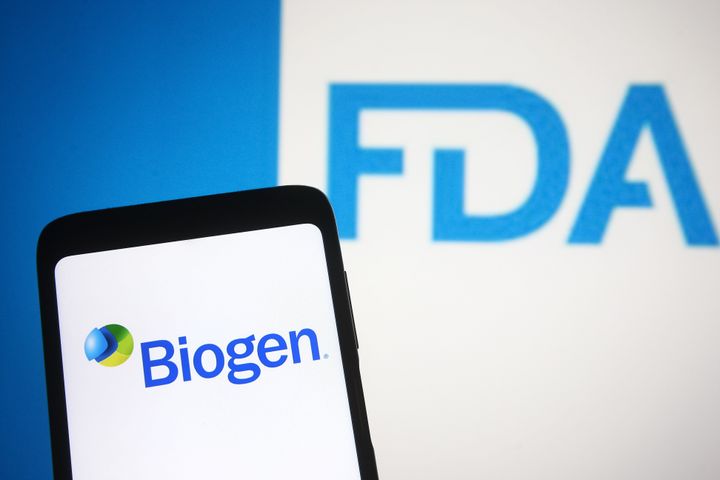 In this photo illustration, the Biogen logo of a biotechnology company is seen on a smartphone screen with a Food and Drug Administration (FDA or USFDA) logo in the background. The U.S. FDA approved Biogen's Alzheimer's drug Aduhelm.