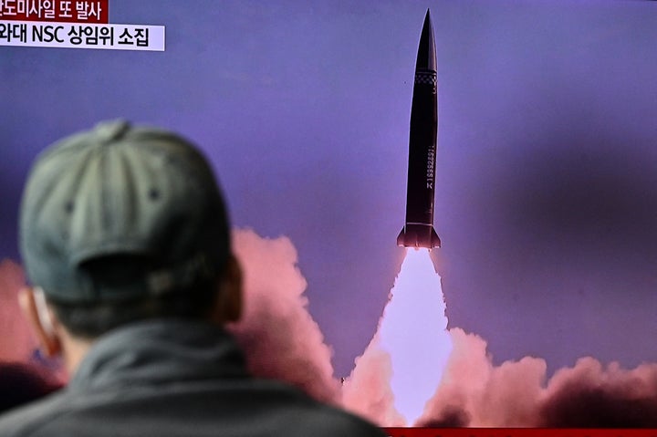 A man watches a television report showing a news broadcast with file footage of a North Korean missile test, at a railway station in Seoul on Oct. 19, 2021.