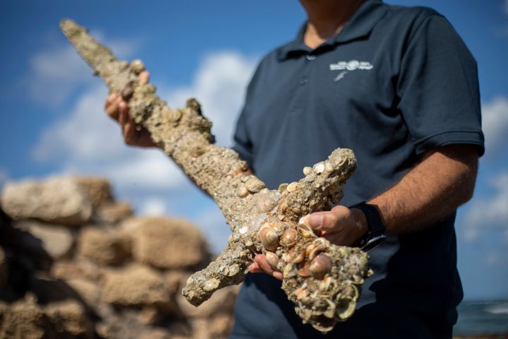 Jacob Sharvit, director of the Marine Archaeology Unit of the Israel Antiquities Authority, holds a meter-long sword that experts say dates back to the Crusaders.