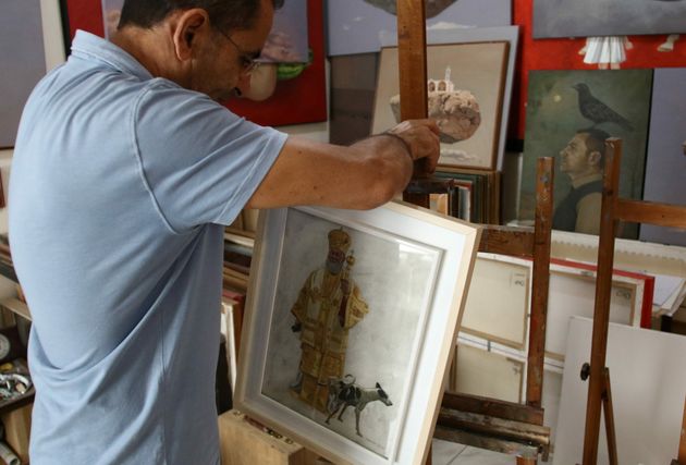George Gavriel places a painting on an easel in his home studio in Kokkinotrimithia, Cyprus, October...