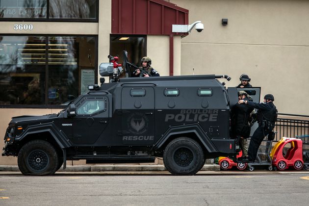 SWAT teams advance through a parking lot as a gunman opened fire at a King Sooper's grocery store on...