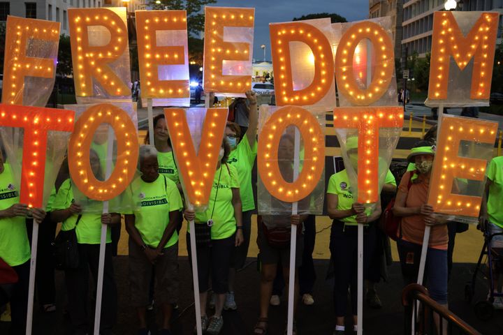 Voting rights activists hold a sign that reads "Freedom To Vote" during a “Good Trouble Candlelight Vigil for Democracy” at Black Lives Matter Plaza on July 17, 2021, in Washington, D.C.