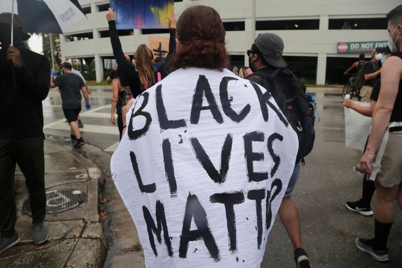 A woman is draped with a cloth reading Black Lives Matter during a protest over the murder of George Floyd on June 2, 2020, in Miami.
