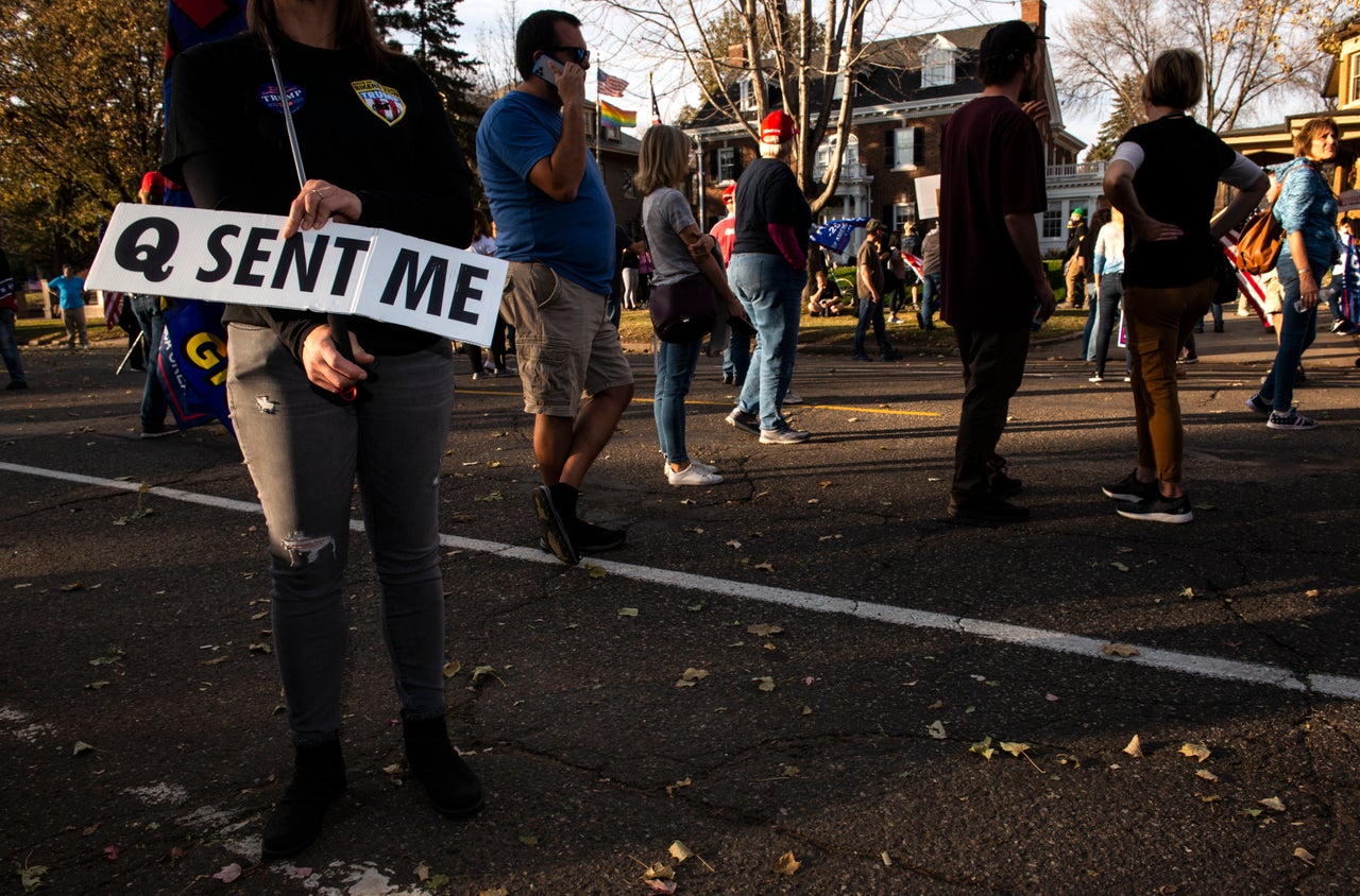 A woman holds a sign referencing the QAnon conspiracy as supporters of President Donald Trump gather outside the Governor's Mansion on Nov. 7, 2020, in St. Paul, Minnesota.