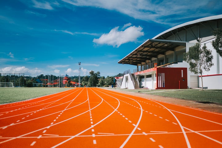 all weather running track with empty bleachers seats in the morning