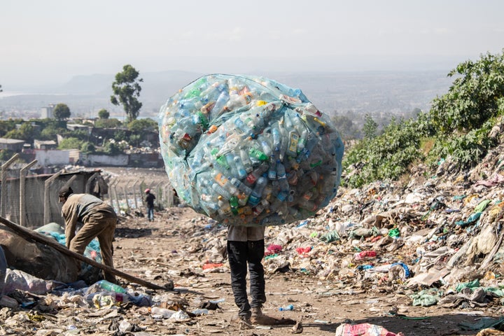 A man in Kenya carries a load of plastic garbage.