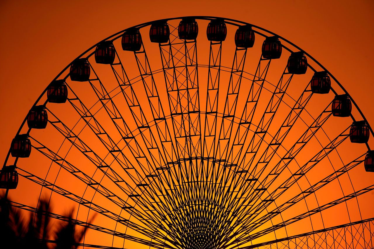 The sun sets while people enjoy a ride at an amusement park in Baghdad, Iraq, on Oct. 21.