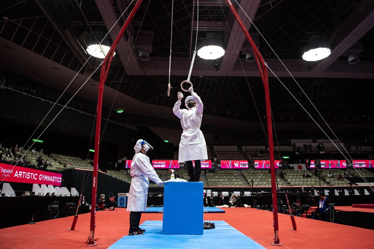Staff members disinfect the rings as a preventive measure against the coronavirus during the Artistic Gymnastics World Championships at the Kitakyushu City Gymnasium in Japan, on Oct. 20.