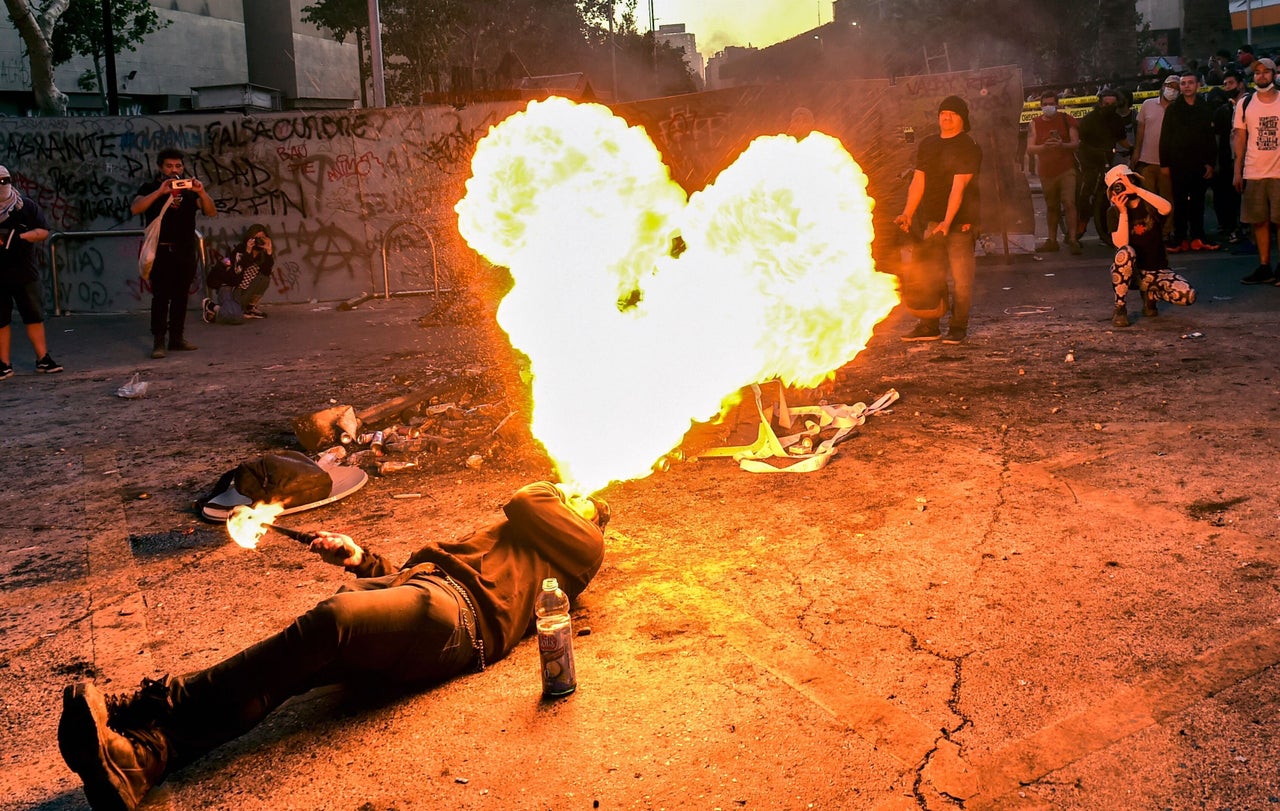 A protester spits fire during a protest to mark the second anniversary of an uprising against social inequality, in Santiago, Chile, on Oct.18. 