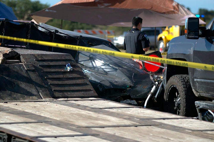 A police officer stands watch over the scene of a fatal drag racing crash at the Kerrville-Kerr County Airport in Kerrville, Texas, on Saturday.