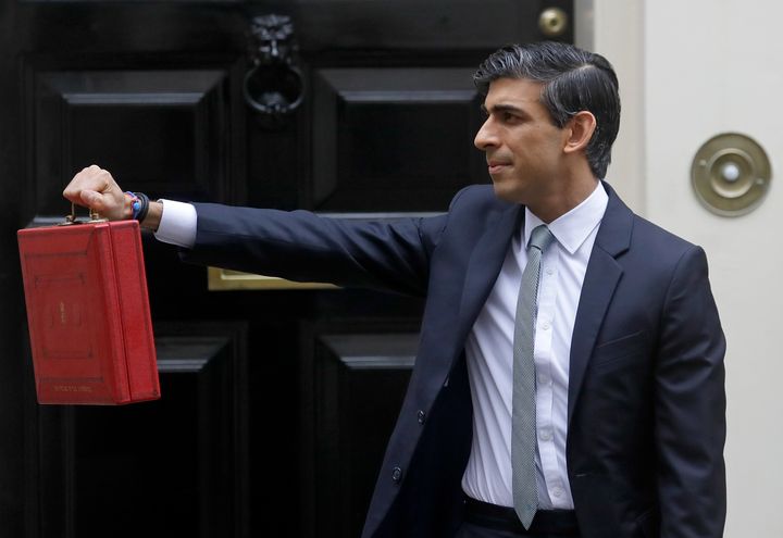 Chancellor Rishi Sunak stands with his red briefcase in front of 11 Downing Street in March.