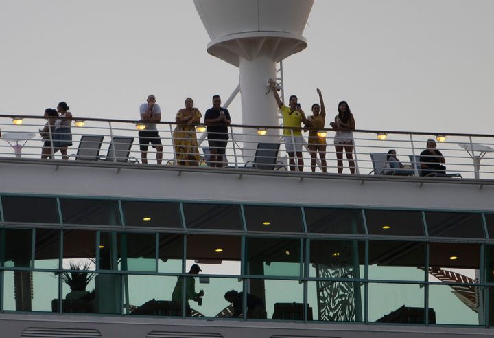 Passengers wave as the Royal Caribbean Freedom of the Seas embarks from Miami back in June during the first U.S. trial cruise, which was testing COVID-19 protocols.