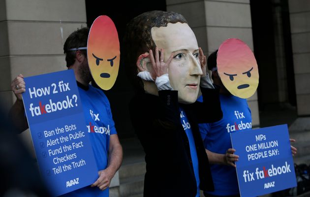 Des manifestants anti-Facebook avec un masque d'émoji 