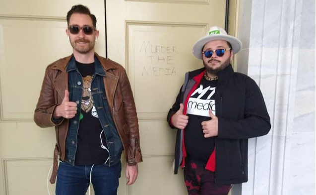 Nicholas Ochs, left, and Nicholas DeCarlo pose in front of the “Murder the Media” graffiti at the U.S. Capitol on Jan. 6.