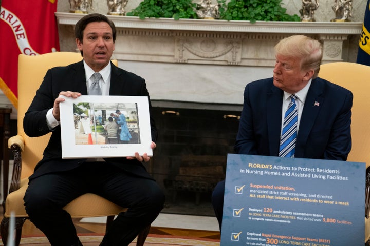 President Donald Trump listens as Gov. Ron DeSantis talks about the coronavirus response during a meeting in the Oval Office of the White House on April 28, 2020.