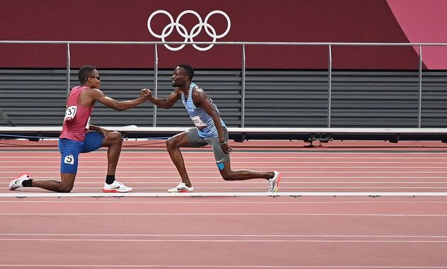 転倒後に握手するアモス選手（右）とジュエット選手。この後、一緒にゴールした（2021年8月1日）