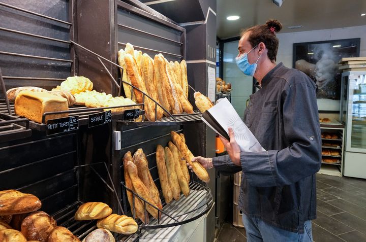 Baker Hugo Hardy prepares baguettes to be sold at Bigot bakery in Versailles, west of Paris, Tuesday, Oct. 26, 2021. 